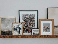 several framed pictures are sitting on a shelf