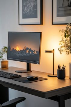 a desktop computer sitting on top of a wooden desk next to a lamp and potted plant