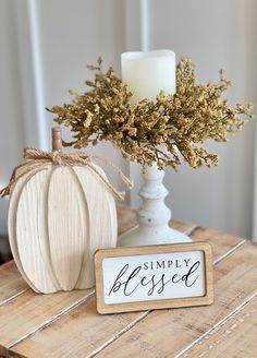 a white pumpkin sitting on top of a wooden table next to a sign that says simply blessing