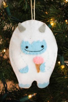 an ornament hanging from a christmas tree with lights around it and a toothbrush in its mouth