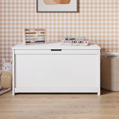 a white toy chest in a room with checkered wallpaper and wooden flooring