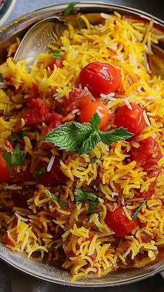 a bowl filled with yellow rice and cherry tomatoes