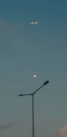 the moon is visible in the sky above a street light