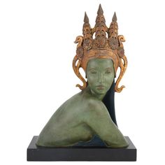 a statue with a crown on top of it's head sitting in front of a white background