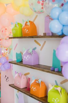 some shelves filled with lots of colorful balloons and paper animals on them'sides,