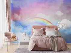 there is a bed with pink sheets and pillows in the room, next to a rainbow wall mural