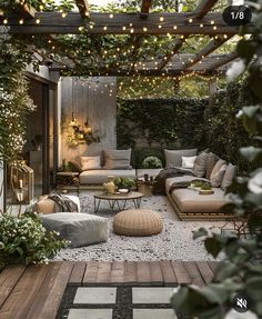 an outdoor living area with couches, tables and lights