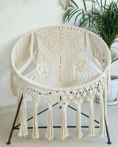 a white chair sitting next to a potted plant