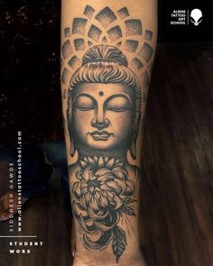 a person with a tattoo on their leg that has a buddha head and flowers around it