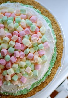 a cake covered in marshmallows on top of a white plate with green trim