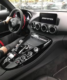 a woman sitting in the driver's seat of a car with her hands on the steering wheel