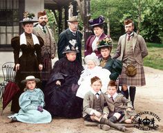 a group of people dressed in period clothing posing for a photo together on the ground