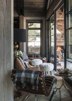 a living room filled with lots of furniture next to large glass windows on the wall