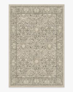 a beige and grey rug with an intricate design on the center, in front of a white background