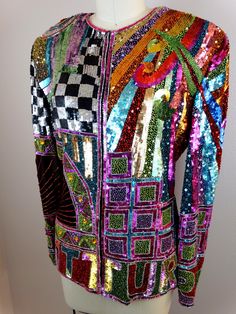 "This is a GORGEOUS vintage couture piece from Naeem Khan RIAZEE! It's fully and heavily embellished with bright sequins and glass beading. The details are AMAZING! It's in perfect condition! There are a total of 10 closures. Measurements are taken with all intact. Measurements: Bust - 34/36\" Waist - 30\" Shoulders - 18\" (hem to hem) Sleeves - 24\" Top to Bottom Length - 25\" Tag Size - Medium All of my items come from a smoke-free and pet-free home. If you have any questions, please don't hes Trophy Jacket, Digital Dress, Checkered Jacket, Beaded Jacket, Naeem Khan, Retro Rainbow, Sequin Jacket, Vintage Couture, Cape Dress