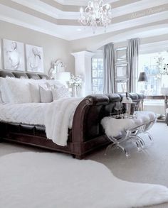 a bedroom with a bed, chandelier and pictures on the wall