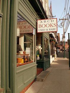 the storefront of an old fashioned book shop with signs on it's windows