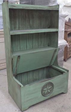 an old green wooden bookcase sitting on top of a floor