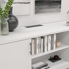 a white book shelf with books and vases on it in front of two pictures