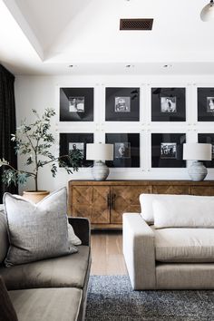 a living room filled with furniture and pictures on the wall