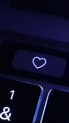 a computer keyboard with a heart on it's illuminated keypad and the word love is written in white