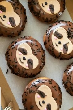 there are six donuts with chocolate frosting in the shape of a monkey face