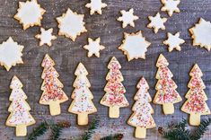 christmas cookies decorated with sugar and sprinkles arranged in rows on a wooden table