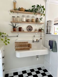 a white sink sitting next to a black and white checkered floor