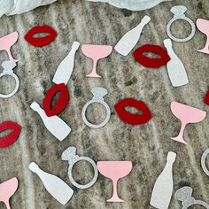 paper cutouts with wine glasses and lipstick are on the ground next to each other