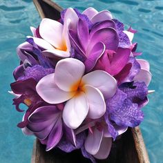 purple and white flowers are on the end of a boat