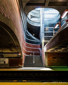 an empty subway station with stairs leading up to it