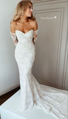 a woman in a white wedding dress posing for the camera with her hands on her hips