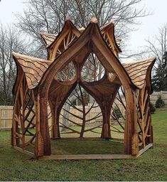 a wooden structure sitting on top of a lush green field