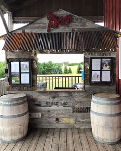 two wooden barrels sitting on top of a wooden floor next to a building with a sign that says boo