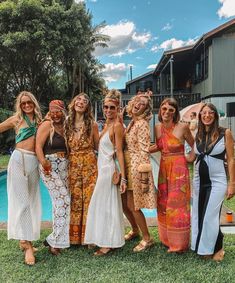 a group of women standing next to each other in front of a pool