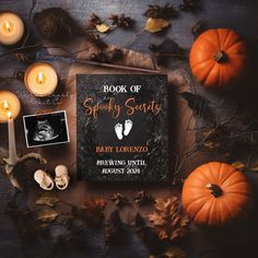 the book of spooky spirits is surrounded by pumpkins and candles