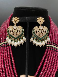 This necklace is a statement piece with a beautiful red/magenta shade and comes with a matching pair of earrings. The length can be adjusted accordingly. The work is high quality stones with a great shine. The necklace comes with statement earrings that can be worn by itself for a simple look. Hand Set Kundan Pendant Earrings, Kundan Pendant Earrings For Celebration, Bollywood Ruby Jewelry With Matching Earrings, Handmade Elegant Chandbali Bridal Necklace, Elegant Chandbali Ruby Jewelry Sets, Elegant Handmade Chandbali Bridal Necklace, Bollywood Kundan Pendant Earrings, Festive Earrings With Stones As Gift, Elegant Ruby Earrings With Stone Work