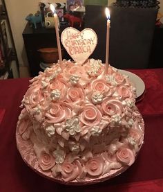 a heart shaped cake with roses and candles