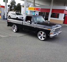 a black truck parked in front of a gas station