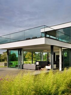 a modern house with glass walls and balconies