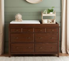 a baby's crib in the corner of a room with a clock above it