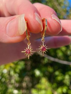 These birthstone wishing star earrings are so gorgeous and dainty. They make for the perfect personalized gift for you or a friend!  *Imitation birthstone  (made with cubic zirconia)  January Birthstone  (Garnet)  Garnet is the stone that symbolizes love and friendship. It is also thought to mend wounds between lovers. It can also symbolize great perseverance and strength.  Materials  -12mm latch back hoops  (tarnish resistant, 18k gold plated) -Garnet birthstone charms  (14k gold plated, cubic Star Shaped Tarnish Resistant Earrings For Gifts, 14k Gold Filled Earrings With Star Charm As Gift, Star Charm Dangle Huggie Earrings As Gift, Dainty Cubic Zirconia Hoop Earrings For Gift, Starburst Cubic Zirconia Jewelry Gift, 14k Gold Filled Star Charm Earrings As Gift, Gift Dangle Huggie Earrings With Star Charm, Gift Huggie Earrings With Star Charm Dangle, Cubic Zirconia Dangle Huggie Earrings For Gift