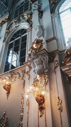 an ornate gold and white wall with chandeliers