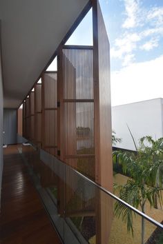 a balcony with wood and glass railings next to palm trees on the other side