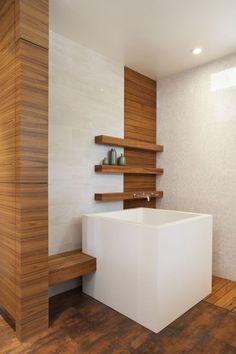 a white bath tub sitting next to a wooden shelf