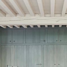 an empty room with several wooden cabinets and benches on the floor, in front of a white painted ceiling