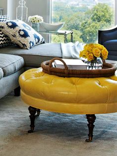 a living room filled with furniture and yellow flowers