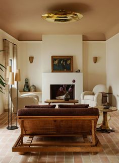 a living room filled with furniture and a fire place in the middle of the room