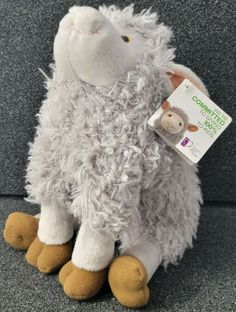 a stuffed sheep sitting on top of a gray couch