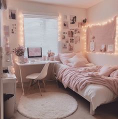 a bedroom decorated in pink and white with lights on the wall